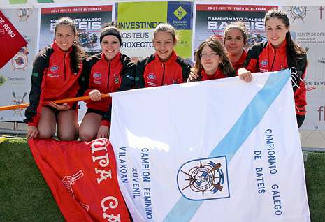 Las flamantes campeonas posan con la bandera conseguida en la mañana de ayer en Vilaxoán. 