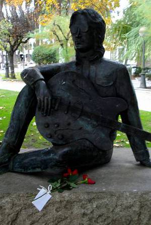 Unas flores y un mensaje en un papel ante la estatua de Lennon en A Coruña. Vicente Fernández