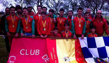 La tripulación de cadetes y la de infantiles posan juntos con la bandera de campeones de España, la de Ferrol y del club de remo A Cabana. 